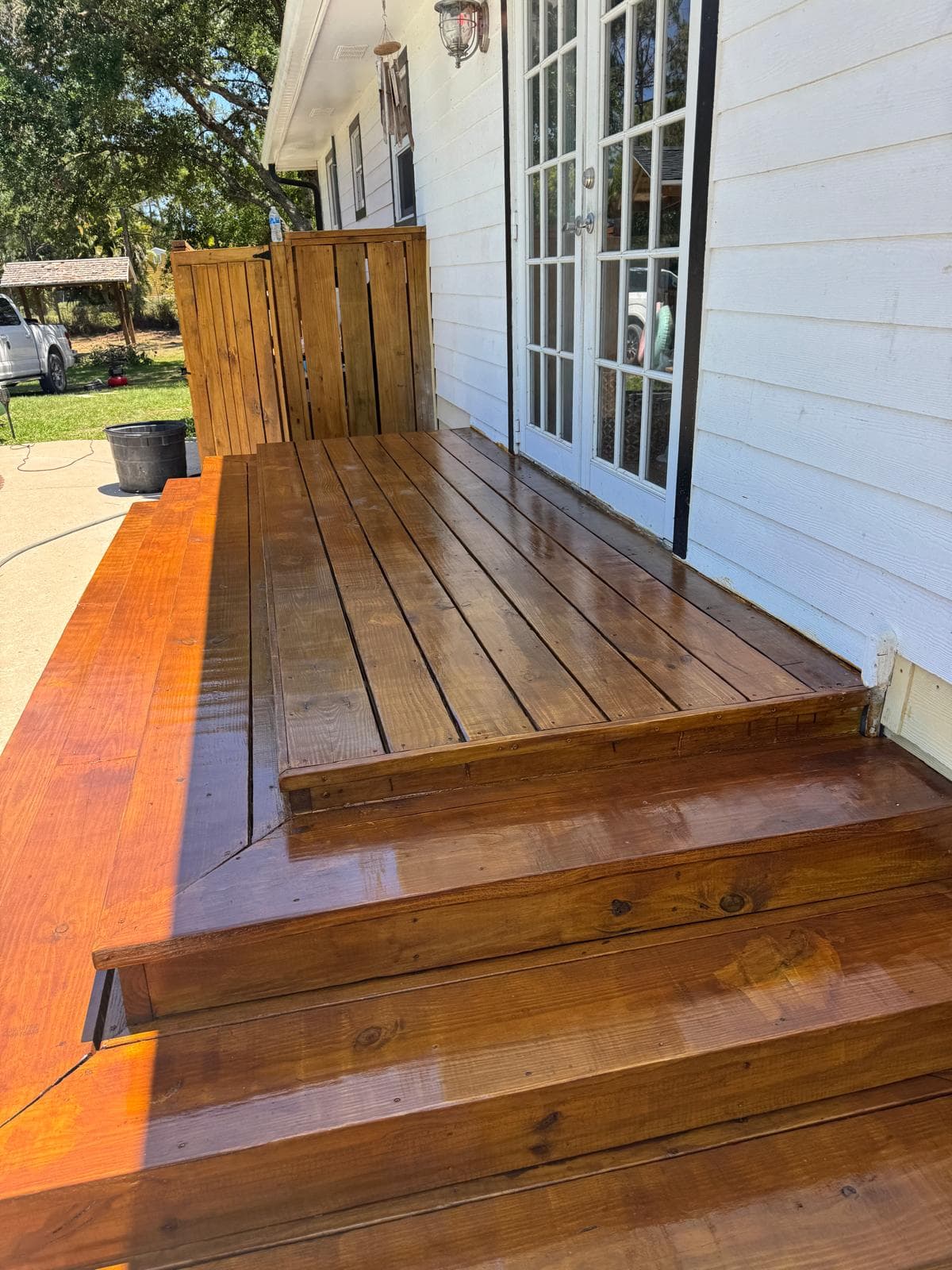 Stained cedar deck with French door entry by Benito Fine Carpentry Wellington Florida