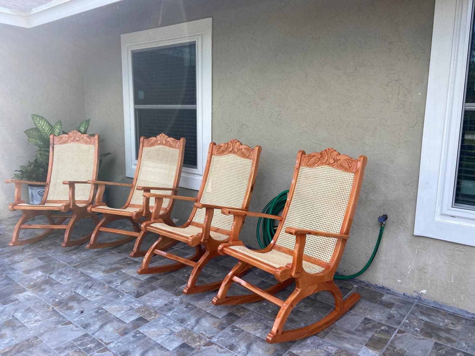 Set of four hand-carved mahogany rocking chairs with cane backs and ornate detailing by Benito Fine Carpentry
