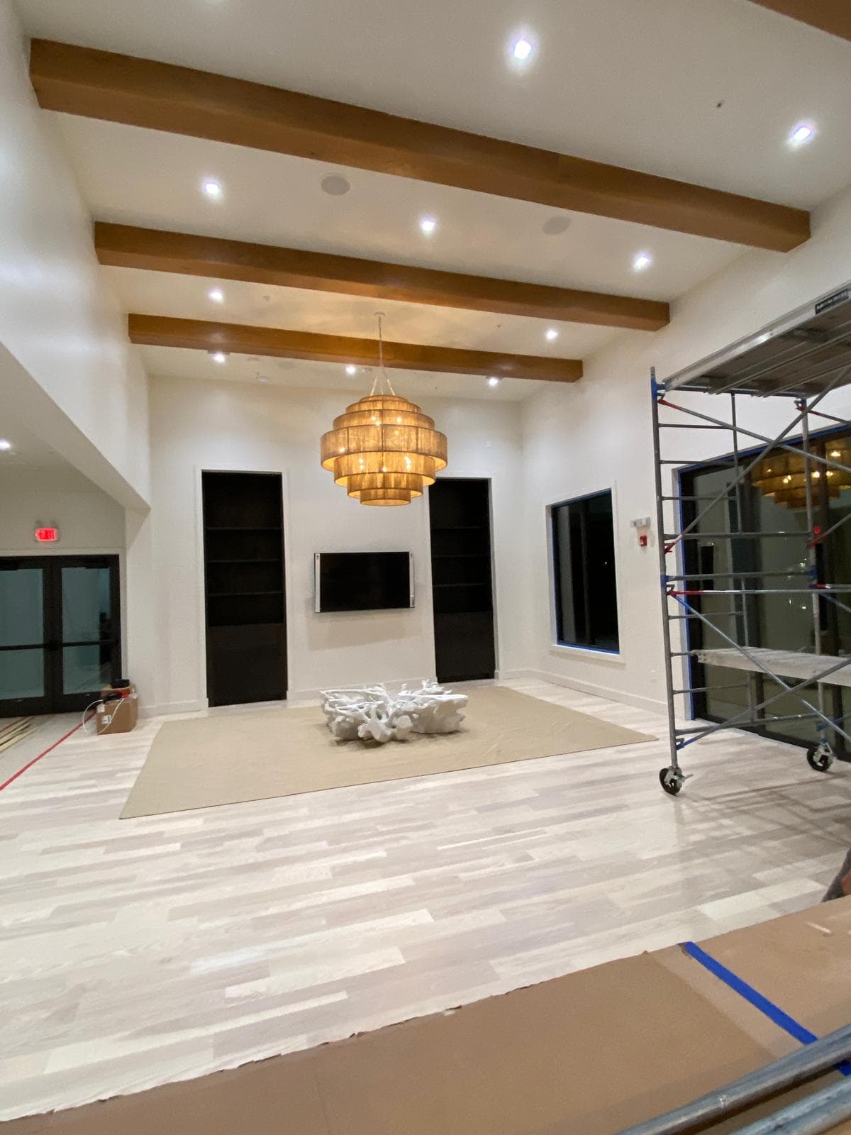 Luxury estate room with exposed wood ceiling beams and woven chandelier by Benito Fine Carpentry Palm Beach