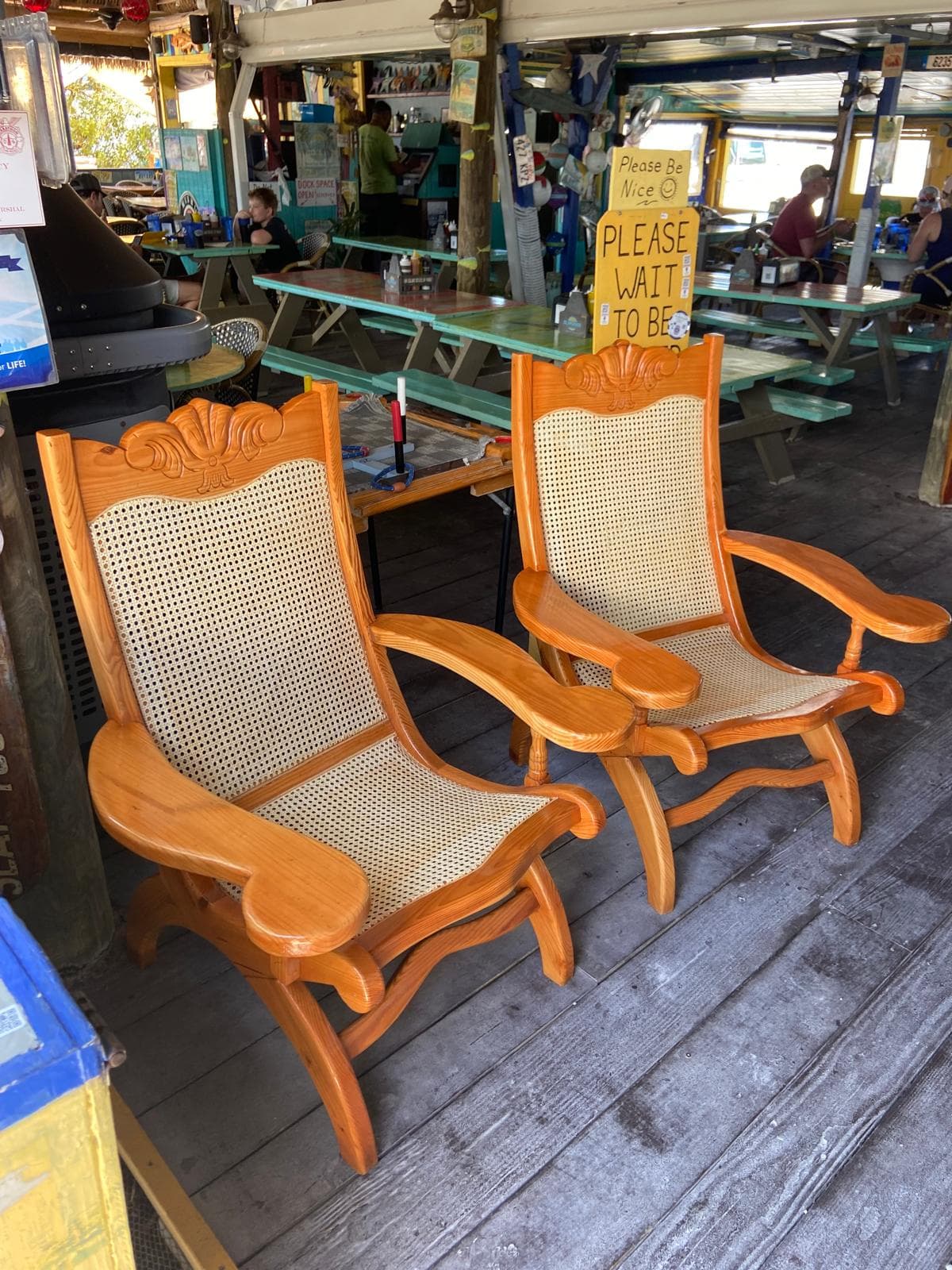 Pair of hand-carved plantation chairs with cane backs in commercial setting by Benito Fine Carpentry South Florida