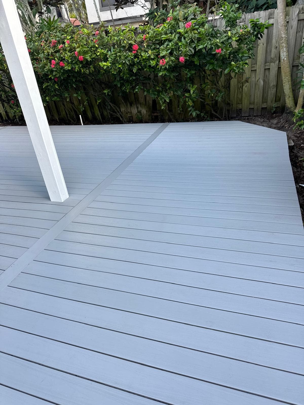 Clean gray Trex composite deck boards with white pergola column by Benito Fine Carpentry Palm Beach County FL
