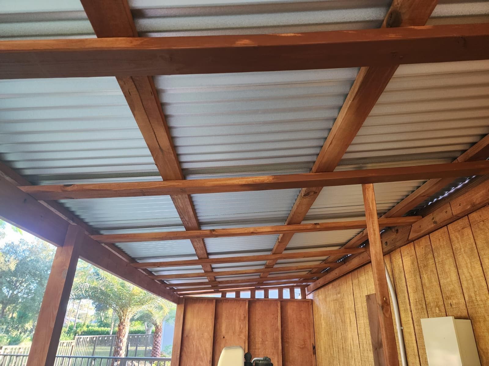 Interior beam grid and corrugated metal roof of custom water filter enclosure by Benito Fine Carpentry