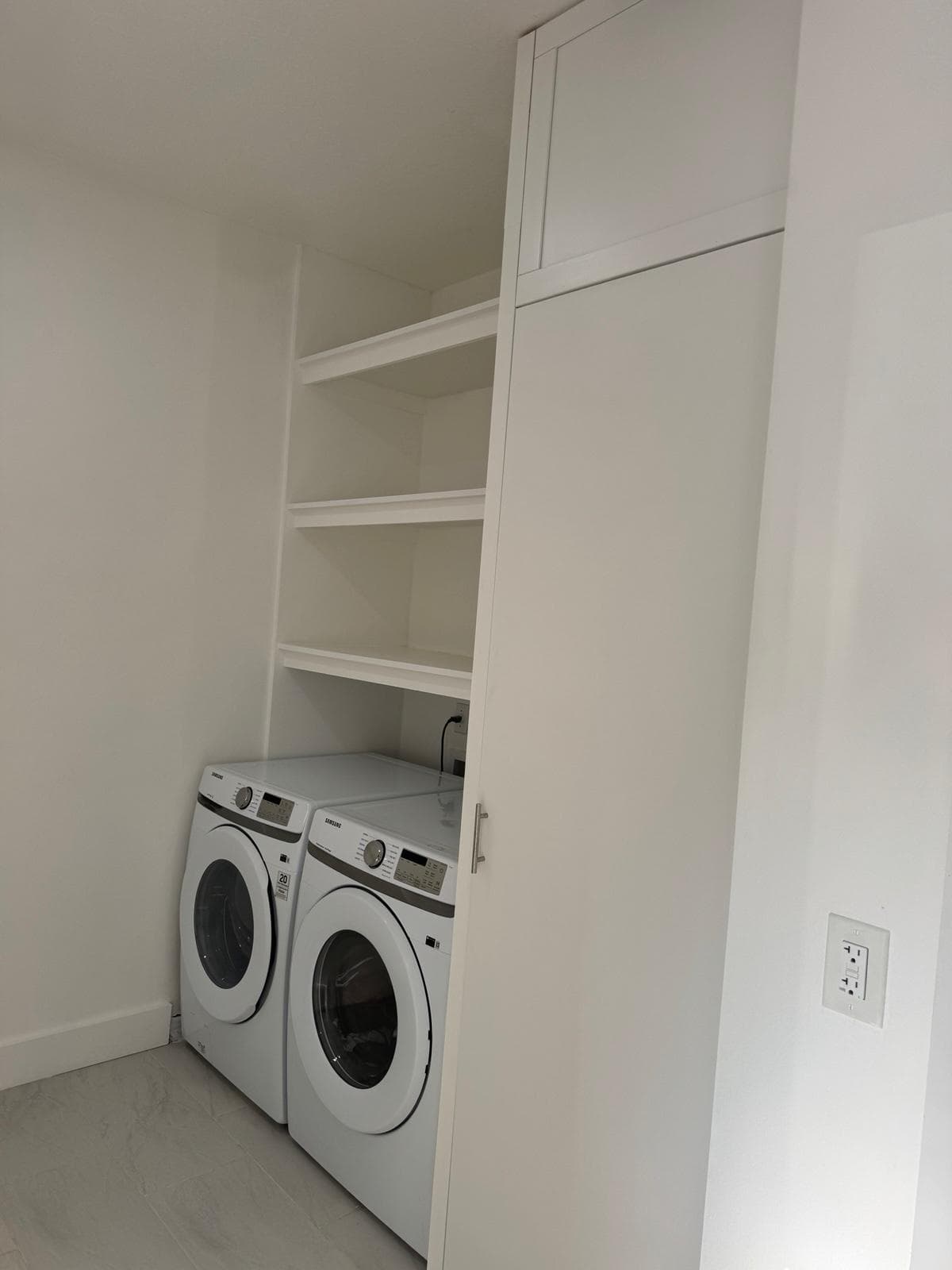 Custom white laundry room built-in shelving and cabinetry by Benito Fine Carpentry Wellington FL