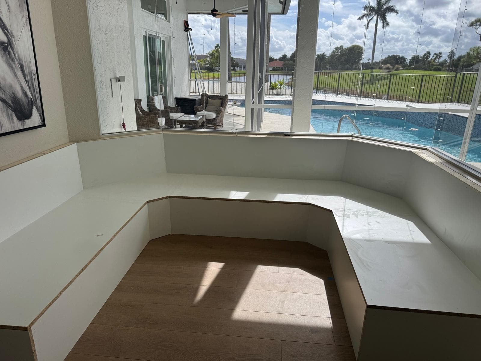 U-shaped built-in banquette with marble top overlooking pool by Benito Fine Carpentry Palm Beach