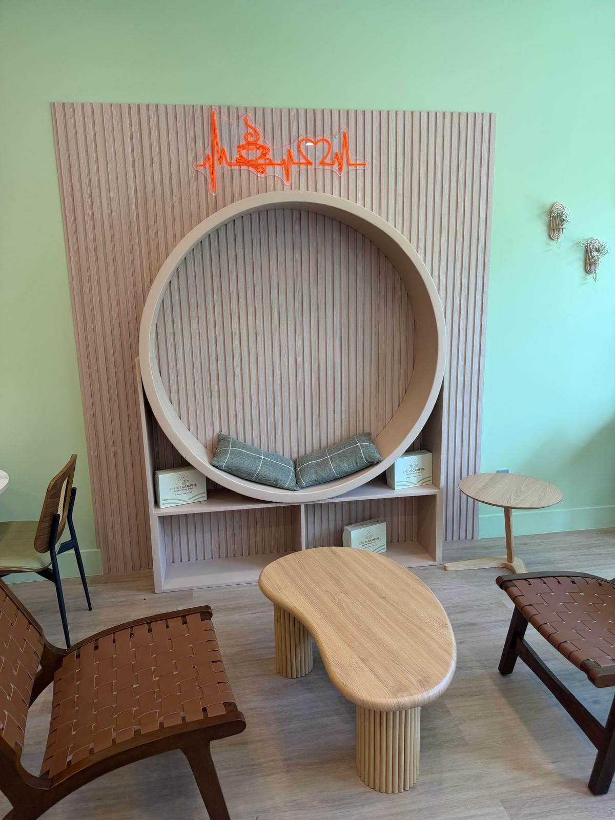 Custom wood slat feature wall with circular built-in and neon sign — commercial build by Benito Fine Carpentry