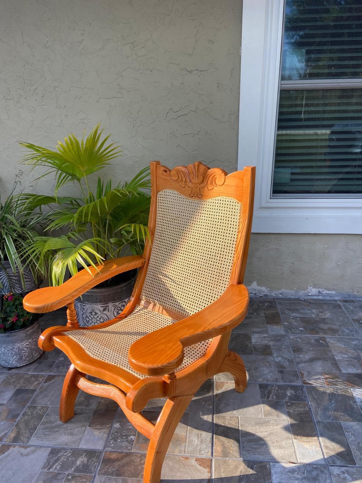 Custom hand-carved oak rocking chair with cane back and ornate detailing by Benito Fine Carpentry