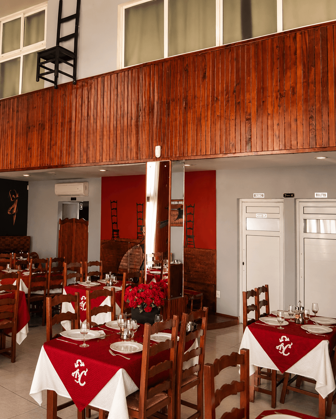 Hotel restaurant interior with rich mahogany wood wall paneling and mezzanine millwork by Benito Fine Carpentry