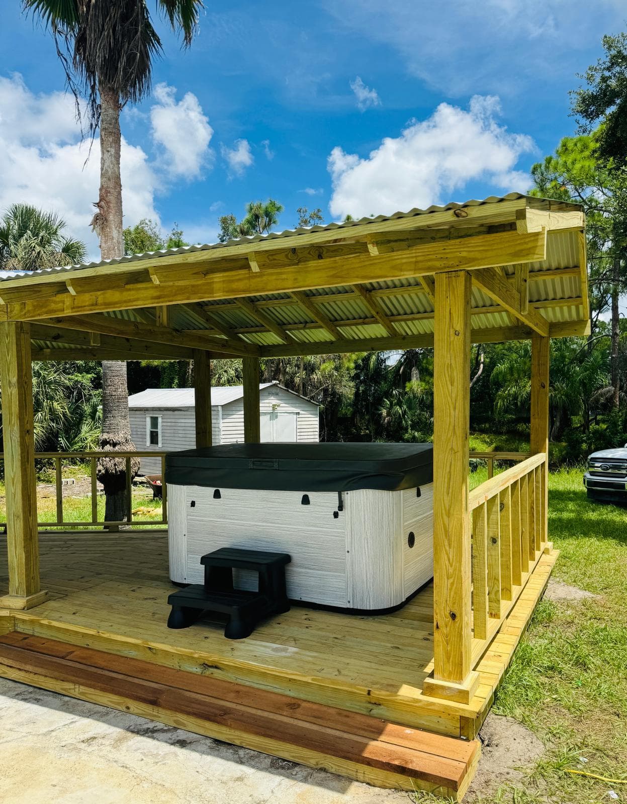 Custom cedar hot tub pavilion with corrugated metal roof and deck by Benito Fine Carpentry Wellington FL