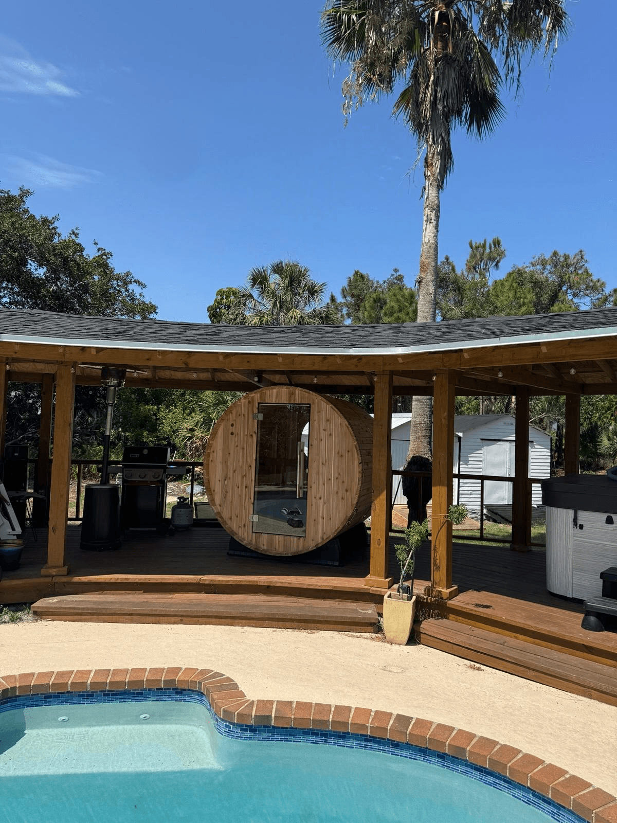Custom curved cedar pavilion with barrel sauna and pool deck built by Benito Fine Carpentry Wellington FL