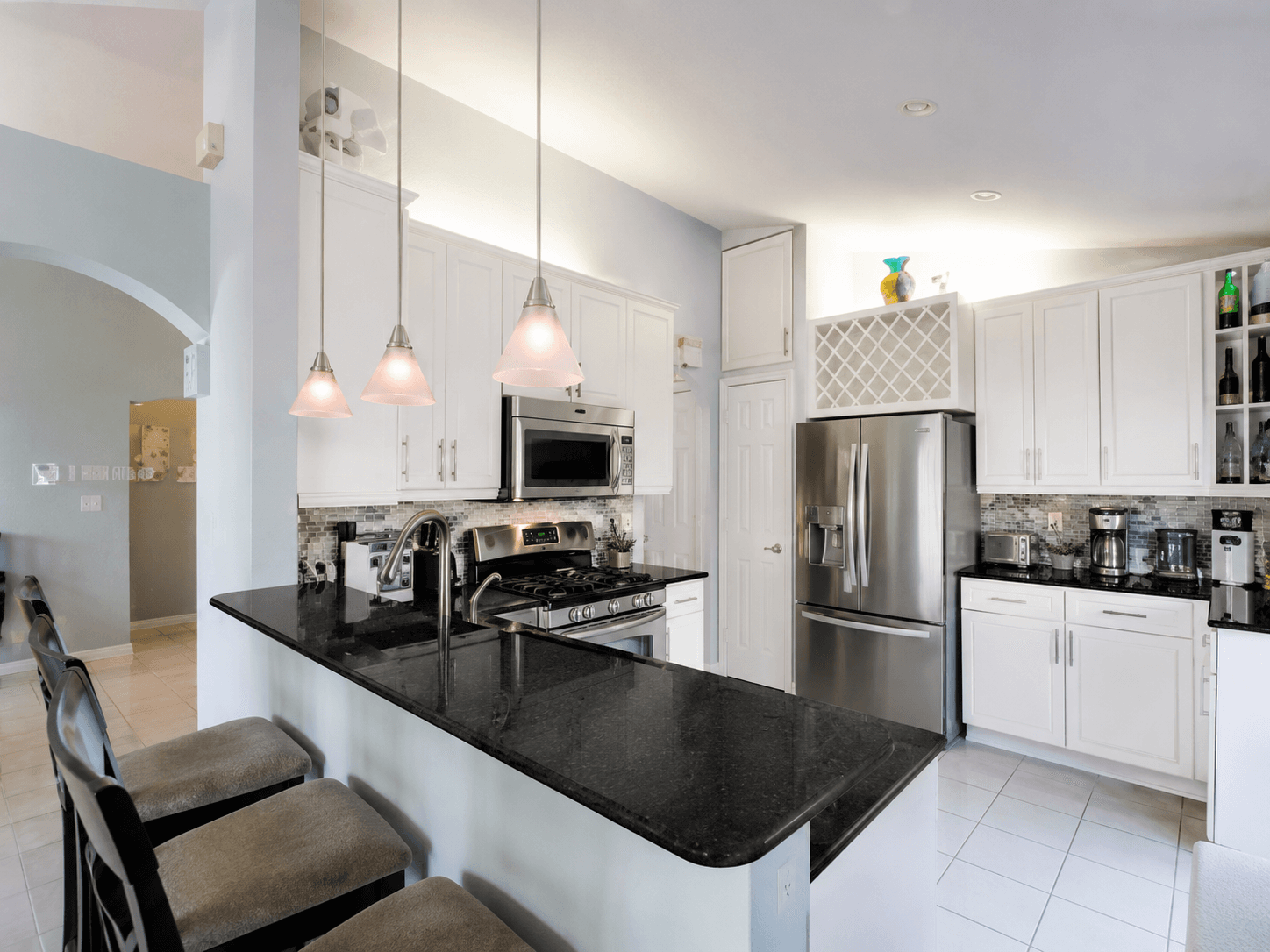 Kitchen remodel with black granite countertops white shaker cabinets and pendant lighting by Benito Fine Carpentry Palm Beach County