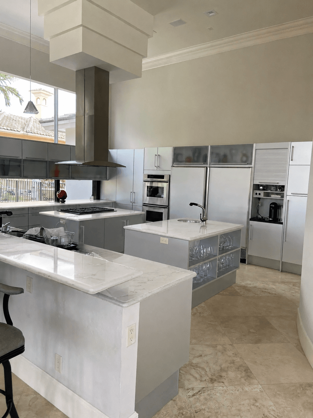 Modern kitchen remodel with white marble countertops white cabinets and black hardware by Benito Fine Carpentry Wellington FL